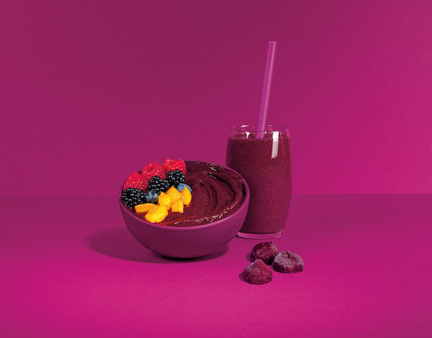 Açaí Smoothie und Bowl auf lila Hintergrund